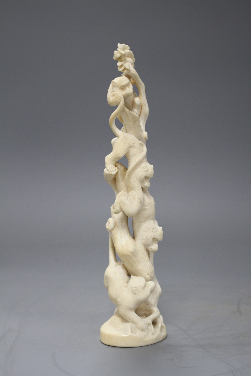 A Japanese Meiji period Tokyo School okimono carved with monkeys climbing a tree, unsigned, height 21.5cm